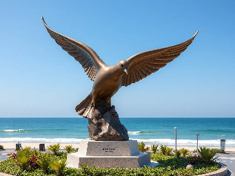 eautifully sculpted, large-sized bronze dove is captured in mid-flight, symbolizing peace and freedom. The monument is situated in a public park right along the scenic beachfront of Sihanoukville, Cambodia. The base is surrounded by a lush coastal garden with native salt-tolerant plants and beach vegetation. Bright daylight, clear blue sky, soft ocean waves in the background, photorealistic, architectural rendering style, highly detailed stone and polished metal textures, 8k resolution.